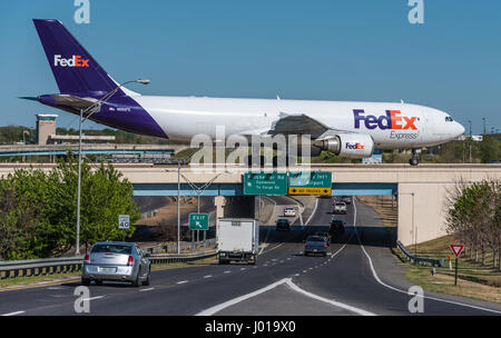 FedEx cargo jet (Airbus A300) on taxiway bridge over airport entrance road at Memphis International Airport (FedEx headquarters) in Memphis, TN, USA. Stock Photo