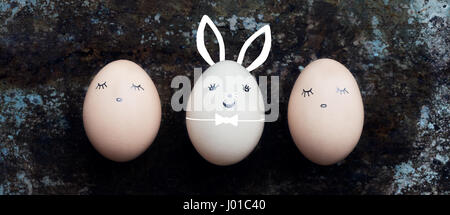 Three cute easter eggs with faces, happy easter bunny retro background Stock Photo