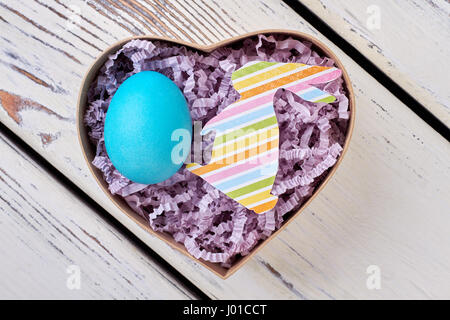 Easter gift box, wood surface. Blue chicken egg. Stock Photo
