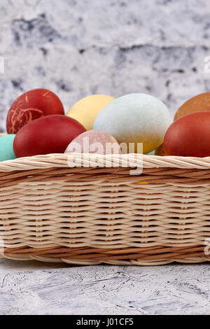 Dyed eggs in a basket. Wicker basket, side view. Stock Photo