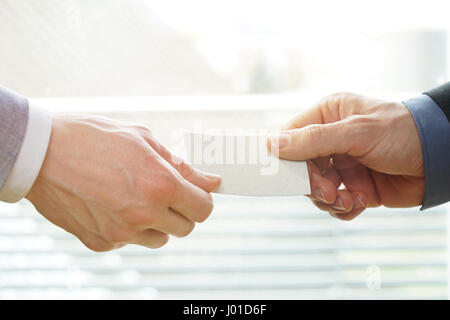 Businesspeople exchanging Visiting Card In Office with sunshine Stock Photo