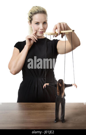 business woman puppet master pulling on strings of a doll Stock Photo