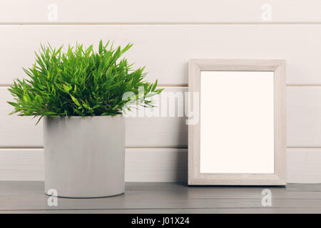 home decoration - blank picture frame and flower pot on wooden table Stock Photo