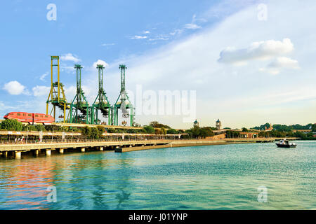 Passenger Express Train and loading cranes of Sentosa Island, in Singapore. Port Container terminal on the background Stock Photo