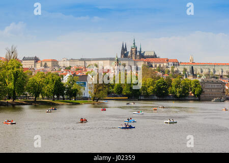 View of the city Prague in Czech Republic with colorful paddle boats on the Vltava river on a beautiful day (Czechia) Stock Photo