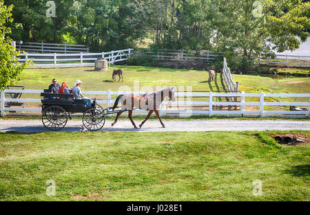 Lancaster, Pennsylvania - September 10, 2016 - Amish men give tourists a ride in a traditional buggy on a historic farm in Amish Country Pennsylvania. Stock Photo