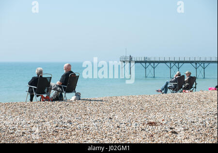 People sitting on chairs on the beach enjoying a sunny day in Bognor Regis, West Sussex, England. Stock Photo