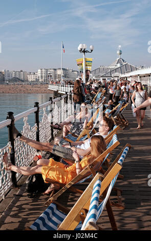 Brighton UK 9th April 2017 -  Visitors enjoy sunbathing on Brighton Palace Pier on the hottest day of the year so far  with temperatures reaching as high as 24 degrees celsius in some parts of the country  Credit: Simon Dack/Alamy Live News Stock Photo