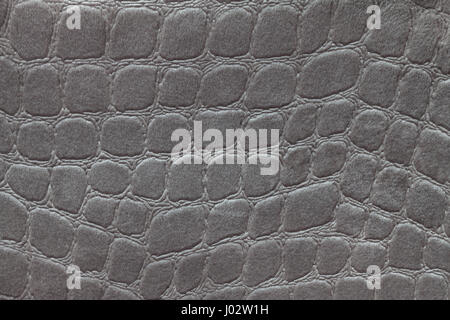 Dark gray background from a soft upholstery textile material, closeup. Silver fabric with pattern imitating crocodile skin.. Textured backdrop. Stock Photo