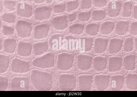 Light pink background from a soft upholstery textile material, closeup. Rose fabric with pattern imitating crocodile skin.. Textured backdrop. Stock Photo