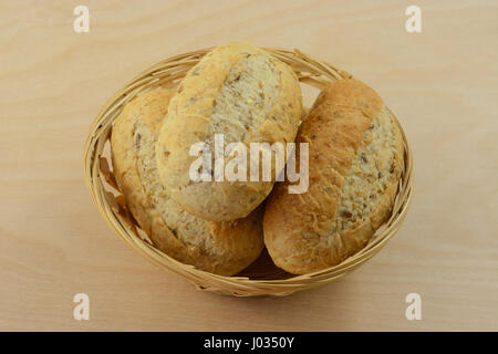 Wholegrain hard rolls in wooden wicker bread basket Stock Photo