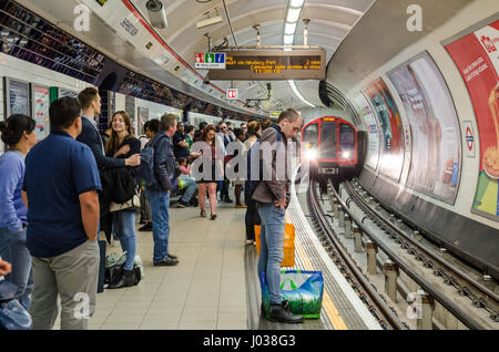 A London Underground train arrives into Shepherds Busd tube station on the Central Line. Stock Photo