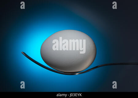 white egg lying on fork Stock Photo