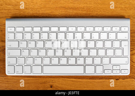 New wireless computer keyboard on a wooden table, close-up Stock Photo