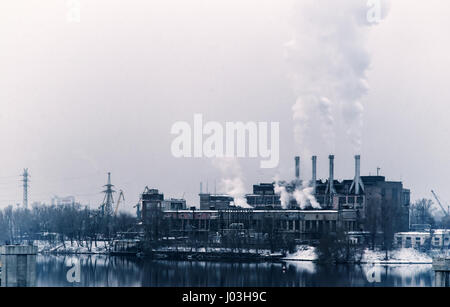 Pollution, plant reflection in the water. Cityscape in grey colors. Stock Photo