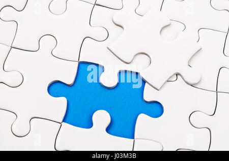 Plain white jigsaw puzzle, on blue background. Stock Photo