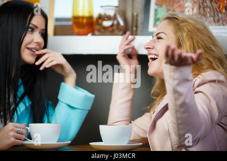 Happy girlfriends talking in cafe Stock Photo