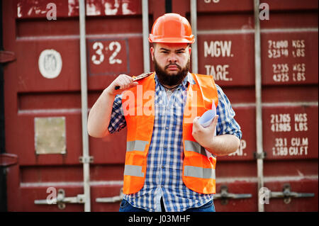 Brutal beard worker man suit construction worker in safety orange helmet with adjustable wrench. Stock Photo