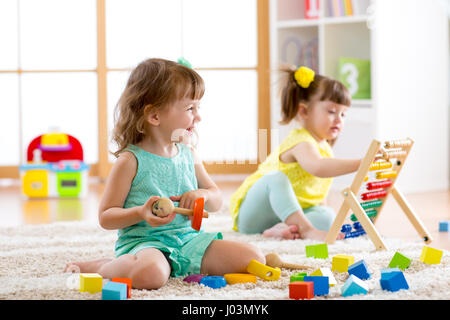 Little kids playing with abacus and constructor toys in kindergarten, playschool or daycare center Stock Photo