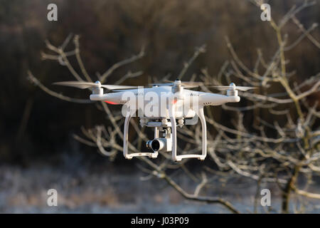 Niedernhausen, Germany - February 25, 2017: DJI Phantom 3 Standard Quadcopter flying in front of wintry vegetation, front view, closeup Stock Photo