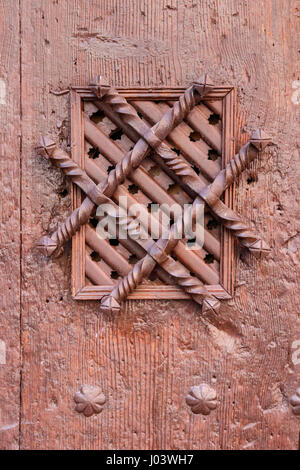 Ornamented spyhole in an old wooden door. Albarracin, Teurel, Spain. Tone filtered to achieve nostalgic effect. Stock Photo