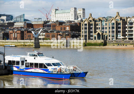 Blue and white Catamaran Thames Clipper boat forming part of the river bus service at Bankside pier by the Millennium Bridge, London, UK Stock Photo