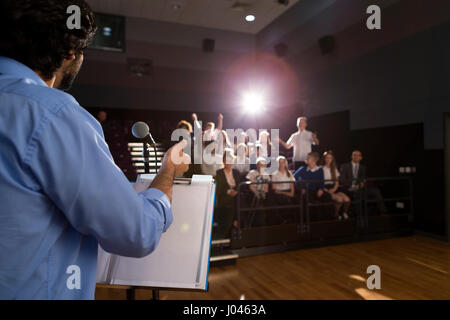 Male teacher giving a speech in a lecture hall to students and teachers. Stock Photo