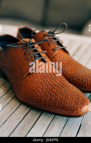 Brown man's shoes with laces on a wooden background. Stock Photo