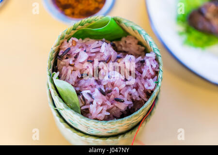 Dark sticky rice inside bamboo container. Cooked glutinous rice or sticky rice. Stock Photo