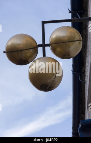 Traditional pawn brokers sign of three gold coloured or brass balls Stock Photo