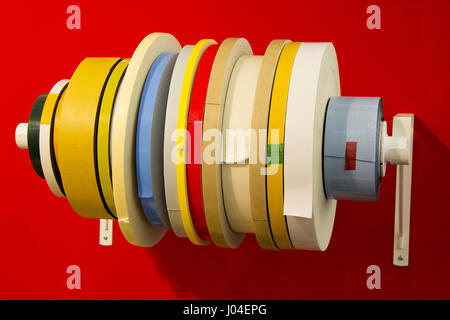 Variety double adhesive tape in; rolls of different types of tape with red background Stock Photo