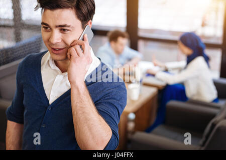 Cheerful pleasant man talking on smartphone Stock Photo