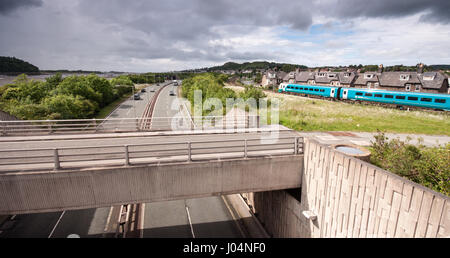 Conwy, Wales, UK - June 16, 2012: An Arriva Trains Wales Class 175 diesel passenger train runs along the Llandudno branch railway, beside the A55 Nort Stock Photo