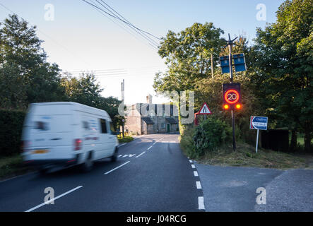 Shaftesbury, England, UK - July 28, 2012: Traffic rushes through Melbury Abbas village in rural north Dorset, activating an electronic speed limit sig Stock Photo