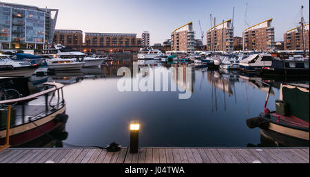 London, England, UK - April 26, 2010: Boats and modern apartment buildings are reflected in the calm waters of Limehouse Basin in the regenerated Dock Stock Photo