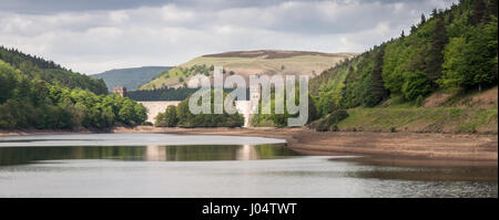 The dam of Howden Reservoir rises from the waters of Derwent Reservoir, part of the string of reservoirs nestled amongst woodland in the Upper Derwent Stock Photo