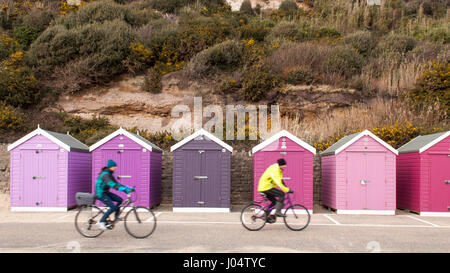 A pair of cyclists ride along the promenade in Bournemouth on a winter afternoon. Stock Photo