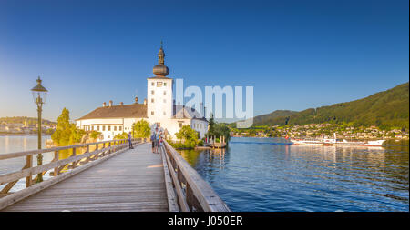 Panoramic view of famous Schloss Ort with traditional paddle steamer ship at Lake Traunsee in evening light at sunset, Gmunden, Salzkammergut, Austria Stock Photo