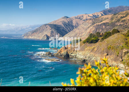 Scenic view of the rugged coastline of Big Sur with Santa Lucia Mountains and Big Creek Bridge along famous Highway 1 at sunset, California, USA