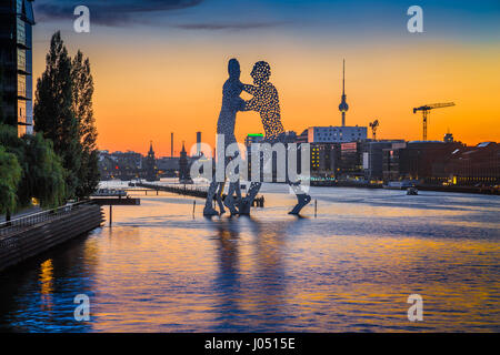 Panoramic view of Berlin skyline with famous Molecule Man sculpture and Spree river in beautiful post sunset twilight at dusk in summer, Germany Stock Photo