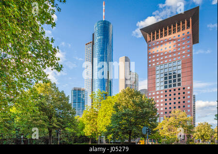 Panoramic view of modern skyscrapers in the financial district of Frankfurt am Main with green trees in public park on a beautiful sunny day in spring