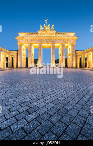 Classic vertical view of historic Brandenburg Gate, Germany's most famous landmark and a national symbol, in post sunset twilight during blue hour at  Stock Photo