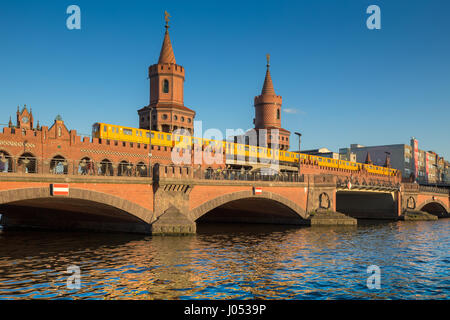 Classic panoramic view of famous Oberbaum Bridge with historic Berliner U-Bahn crossing the Spree river on a beautiful sunny day with blue sky, Berlin Stock Photo