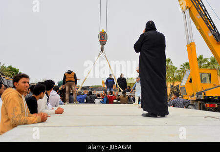 Borg El-Arab, Alexandria, Egypt. 10th Apr, 2017. Egyptian workers use crane to lift coffins of the victims of the blast at the Coptic Christian Saint Mark's church in Alexandria the previous day during a funeral procession at the Monastery of Marmina in the city of Borg El-Arab, east of Alexandria on April 10, 2017. Egypt prepared to impose a state of emergency after jihadist bombings killed dozens at two churches in the deadliest attacks in recent memory on the country's Coptic Christian minority Credit: Amr Sayed/APA Images/ZUMA Wire/Alamy Live News Stock Photo