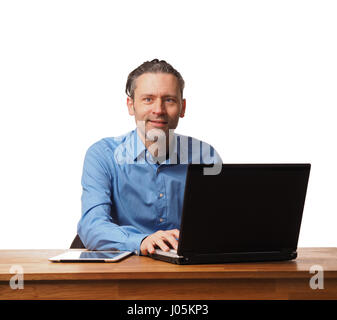 Handsome business man working on an office table with a laptop Stock Photo