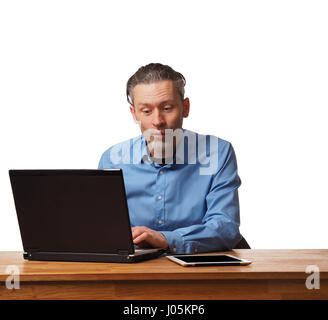 Handsome business man working on an office table with a laptop Stock Photo