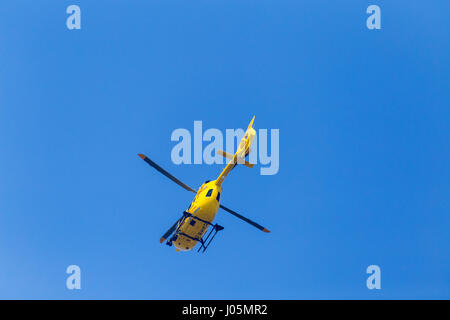 Air Ambulance Operated by East Anglian Air Ambulance Against Clear Blue Sky with Rotor Blades Frozen by Shutter Speed Stock Photo