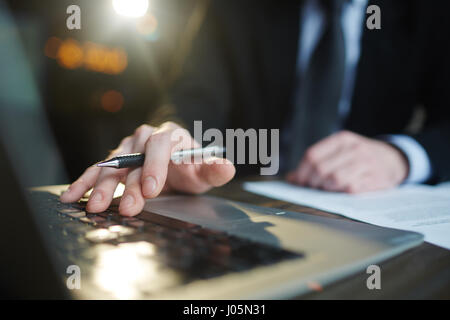 Closeup portrait of modern successful businessman working in office with documentation, closeup shot of male hands using laptop Stock Photo