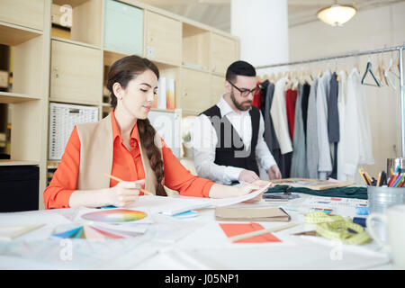Creative woman and man working together in tailoring studio Stock Photo