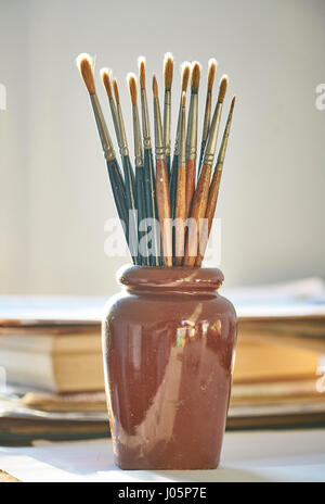 A collection of old sable paintbrushes in a pot Stock Photo